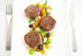 Seared lamb medallions with almond and mint pea cream and baby vegetables